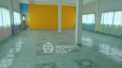 Spacious open room with colorful walls and tiled flooring, ideal for versatile use.