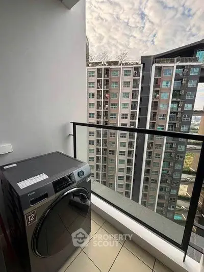 Modern high-rise apartment balcony with washing machine and city view.