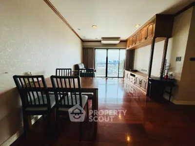 Spacious living room with wooden flooring and city view balcony in modern apartment.