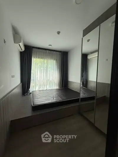 Cozy bedroom with mirrored wardrobe and large window