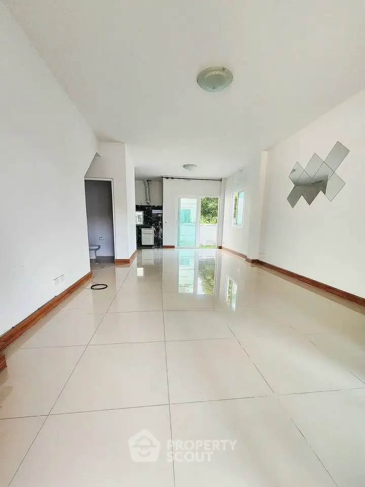 Spacious open-plan living room with glossy tiled floors and modern decor.