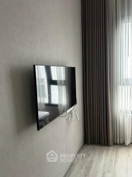 Modern living room with wall-mounted TV and elegant curtains
