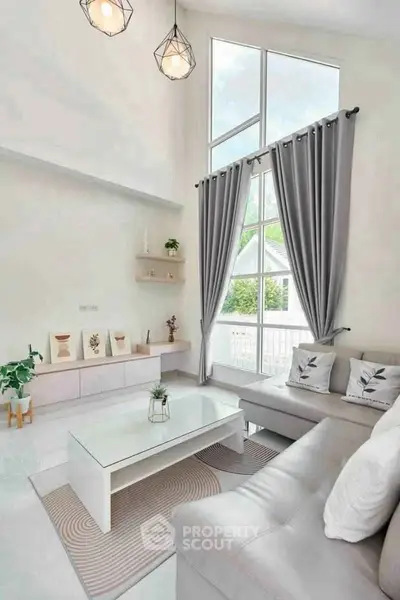 Bright and modern living room with high ceilings and large windows.