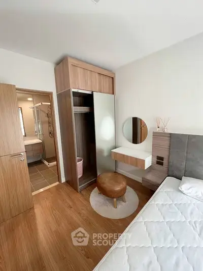 Modern bedroom with wooden flooring, stylish wardrobe, and cozy decor in a contemporary apartment.