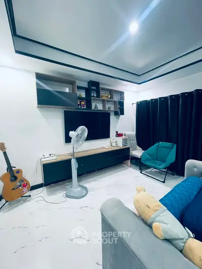 Cozy living room with modern decor, guitar, and entertainment center