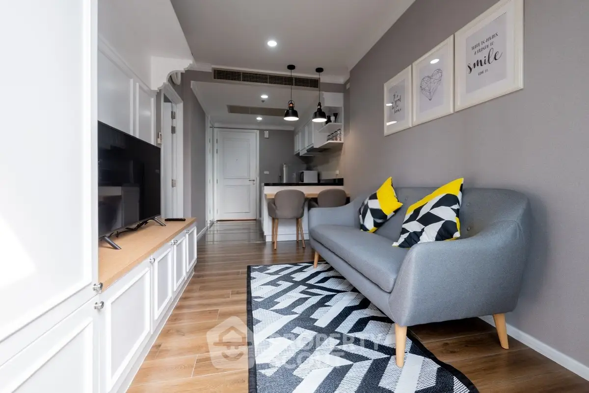 Modern living room with stylish decor and open kitchen layout, featuring cozy seating and elegant lighting.