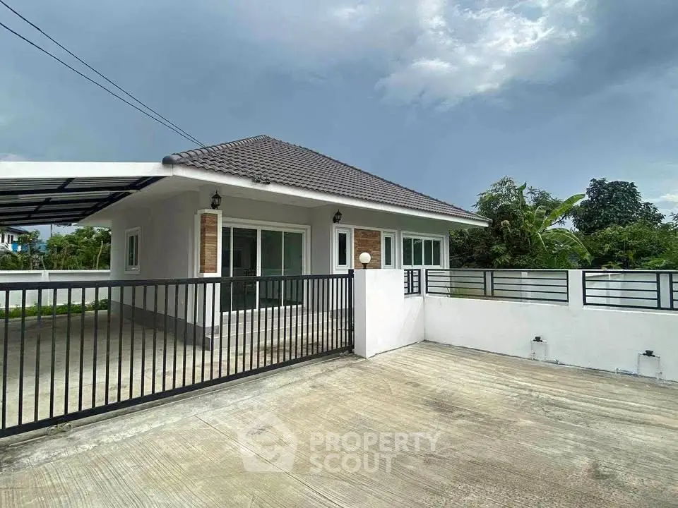 Charming single-story home with spacious driveway and modern fence in serene neighborhood.