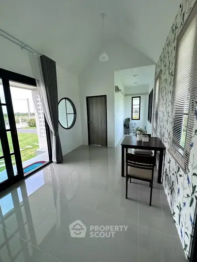 Modern interior with glossy tiles, floral wallpaper, and a small dining area overlooking a garden view.