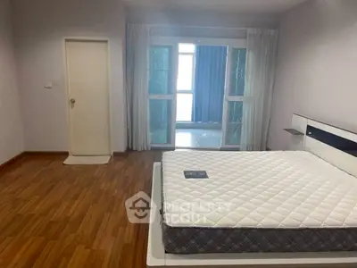 Spacious bedroom with modern design and large windows for natural light.