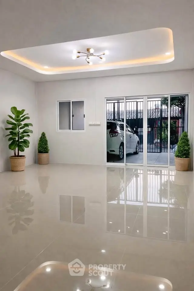 Spacious modern living room with sleek flooring and large sliding glass doors leading to a carport.