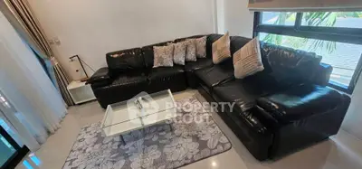 Stylish living room with black leather sectional sofa and modern decor