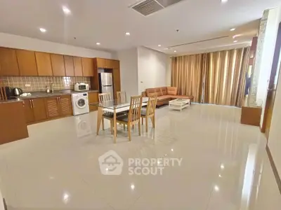 Spacious open-plan living room with modern kitchen and elegant furnishings.