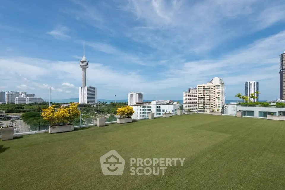 Stunning rooftop view with lush green lawn and cityscape backdrop, perfect for urban living.