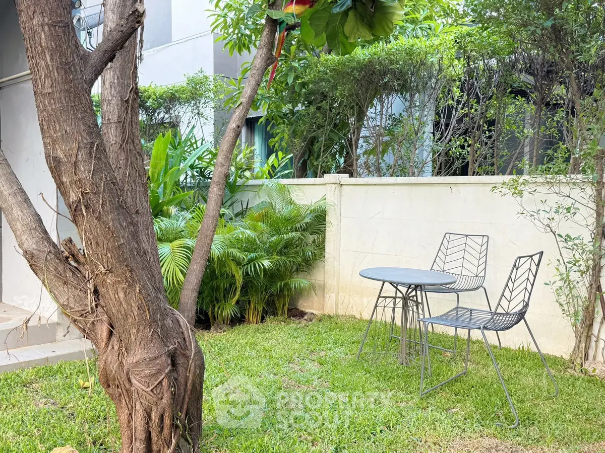 Charming garden with patio set and lush greenery, perfect for relaxation.