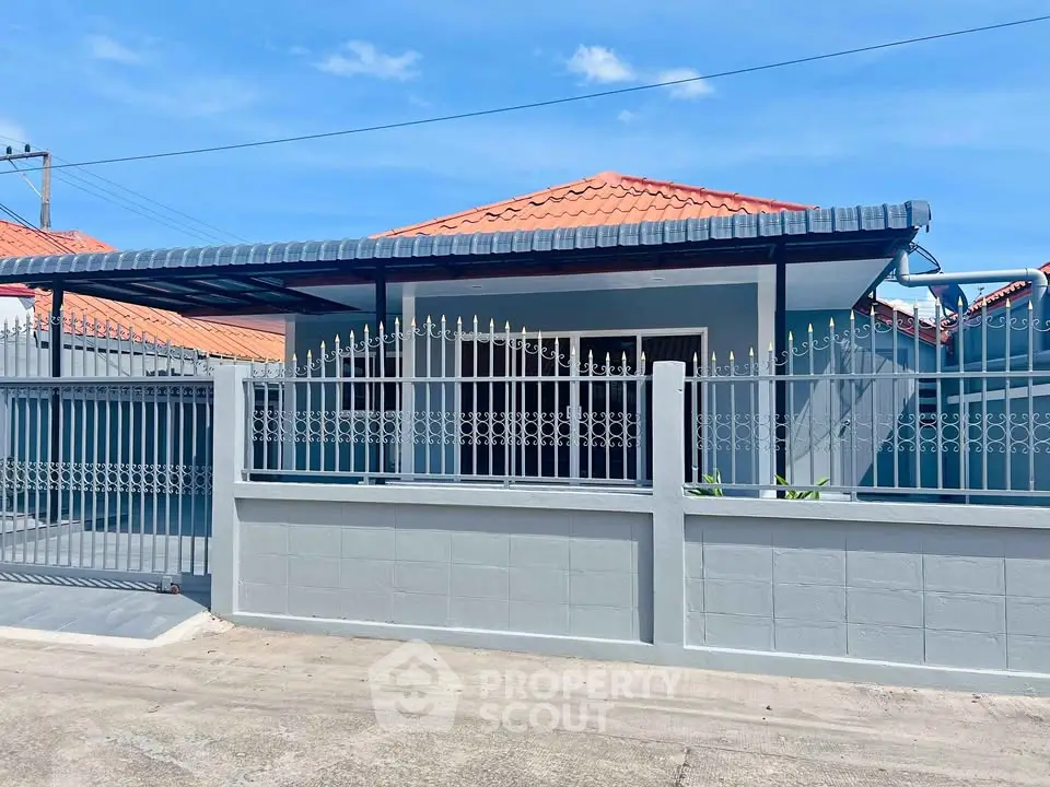 Charming single-story home with red-tiled roof and gated entrance, perfect for family living.
