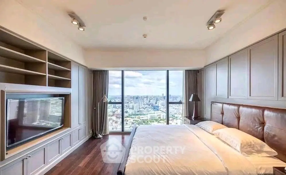 Luxurious bedroom with panoramic city view and elegant furnishings.