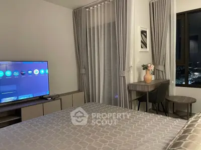 Modern bedroom with stylish decor and city view, featuring a TV and elegant curtains.