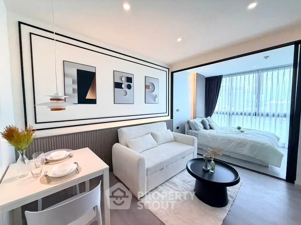 Modern studio apartment with stylish decor and open layout, featuring a cozy living area and elegant bedroom.