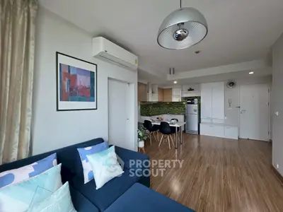 Modern open-plan living room with stylish kitchen and cozy seating area, perfect for urban living.