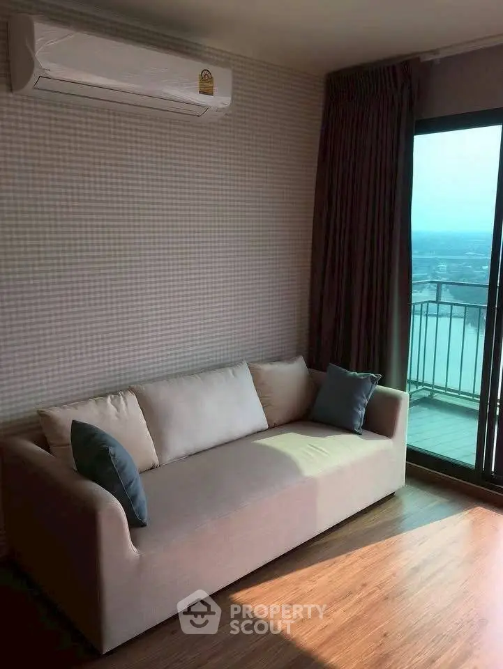 Modern living room with cozy sofa and balcony view, featuring air conditioning and stylish decor.