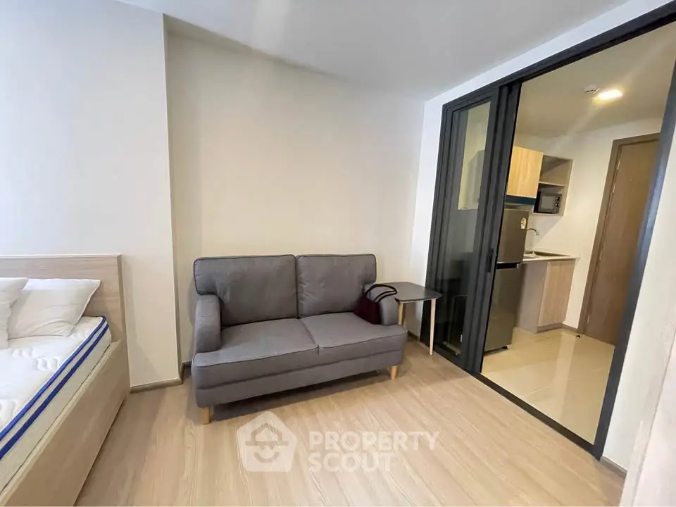 Modern studio apartment with cozy living area and compact kitchen, perfect for urban living.