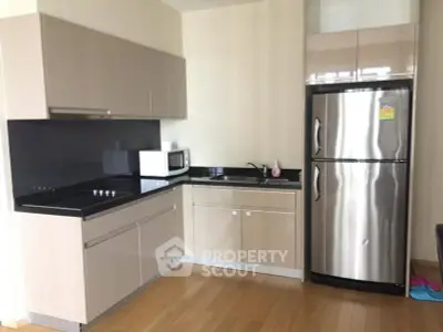 Modern kitchen with sleek cabinetry and stainless steel appliances in a stylish apartment.