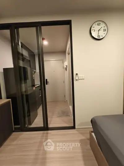 Modern apartment interior with sliding glass door and wall clock