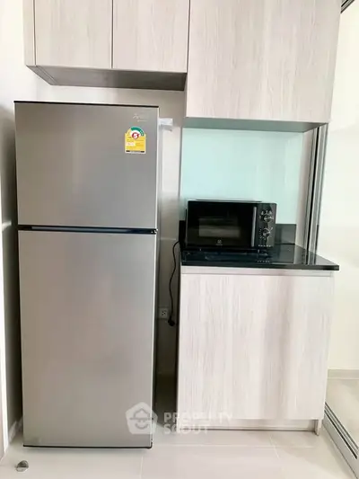 Modern kitchen with sleek fridge and microwave in stylish cabinetry