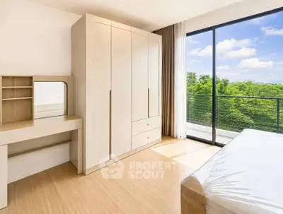 Spacious bedroom with large window offering stunning green views, featuring modern wardrobe and dressing table.