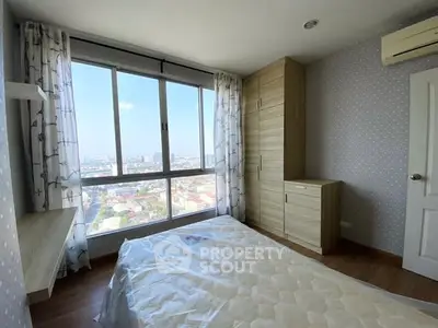 Bright bedroom with large window offering stunning city views and modern furnishings.