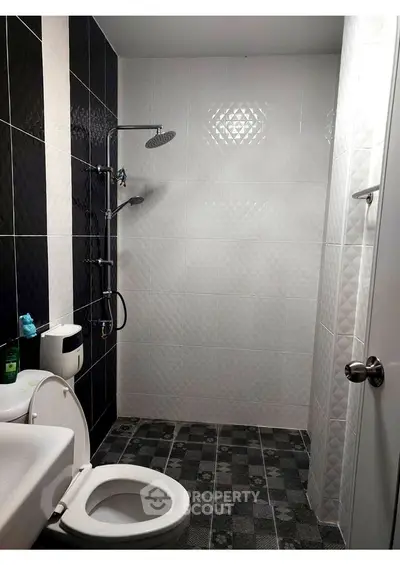 Modern bathroom with sleek black and white tiles and contemporary fixtures.