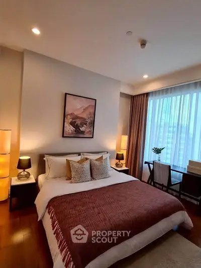 Luxurious bedroom with elegant decor and large window offering natural light.