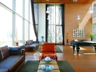 Luxurious living room with high ceilings, large windows, and elegant decor.