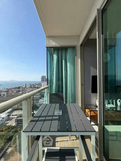 Stunning high-rise balcony with ocean view and modern outdoor furniture.