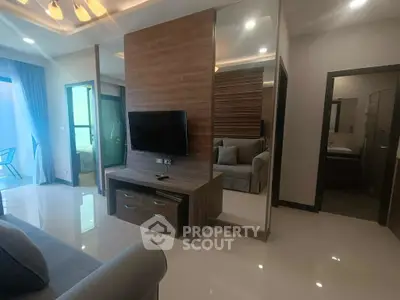 Modern living room with sleek design and wall-mounted TV, featuring a cozy seating area and elegant decor.
