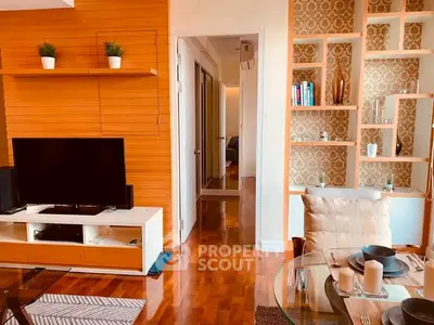 Stylish living room with modern decor and wooden flooring, featuring a TV unit and elegant shelving.