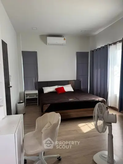 Spacious bedroom with modern decor and natural light