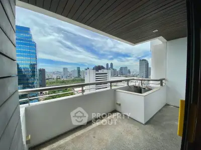 Spacious balcony with stunning city skyline view in modern high-rise apartment.