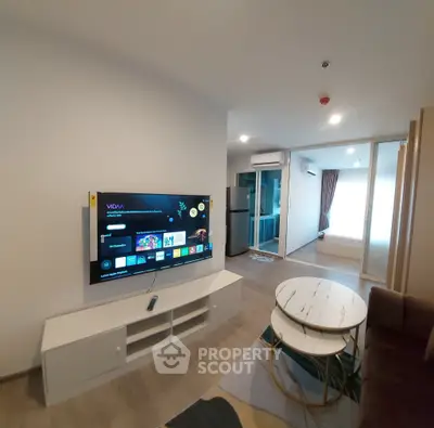 Modern living room with wall-mounted TV and stylish furniture in a contemporary apartment.