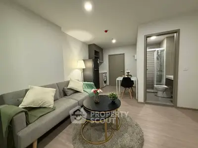 Modern living room with cozy sofa, stylish coffee table, and open kitchen layout