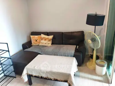 Cozy living room with stylish sofa, modern lamp, and fan, perfect for relaxation.