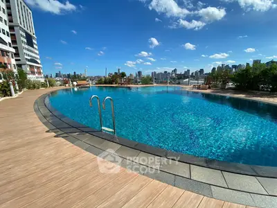 Luxurious rooftop pool with stunning city skyline views and modern deck area.