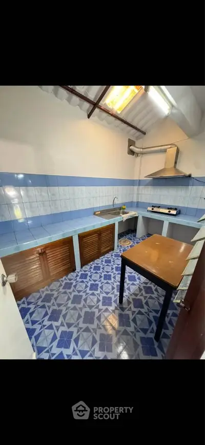 Charming kitchen with blue tile accents and gas stove, perfect for cozy cooking experiences.