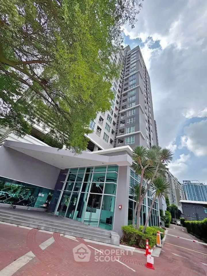 Modern high-rise building with glass facade and lush greenery