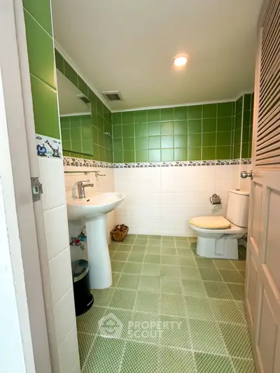 Charming bathroom with green tiles and modern fixtures