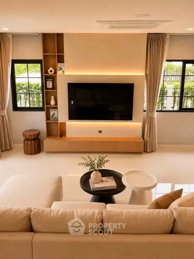 Elegant living room with modern decor and large TV, perfect for relaxation.