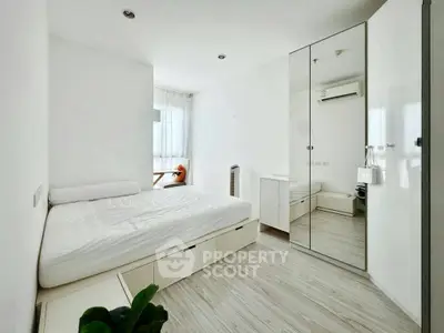 Modern minimalist bedroom with mirrored wardrobe and natural light