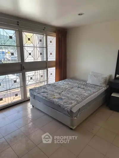 Spacious bedroom with large windows and scenic view, perfect for natural light lovers.