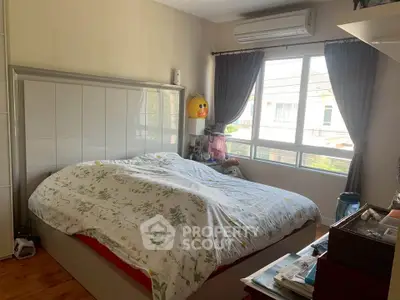Cozy bedroom with large window and air conditioning, featuring a comfortable bed and stylish decor.
