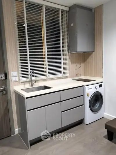 Modern kitchen with sleek cabinetry and integrated washing machine